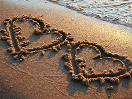 In den Sand gemalte Herzen zur Verlobung