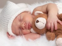 Neugeborenes Baby mit Teddy